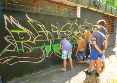 Graffiti Street Art En action sur le mur du foyer dans le quartier du Biollay