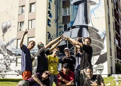 Graffiti Street art Le collectif de la Maise devant la fresque murale " le fou prend la tour " située à Aix les bains en 2015