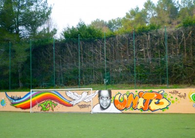 Graffiti Street Art Intervention et décoration avec l'artiste Fazer sur le mur du terrain de football à Valbonne en 2010 Thématique : Paix et Unité